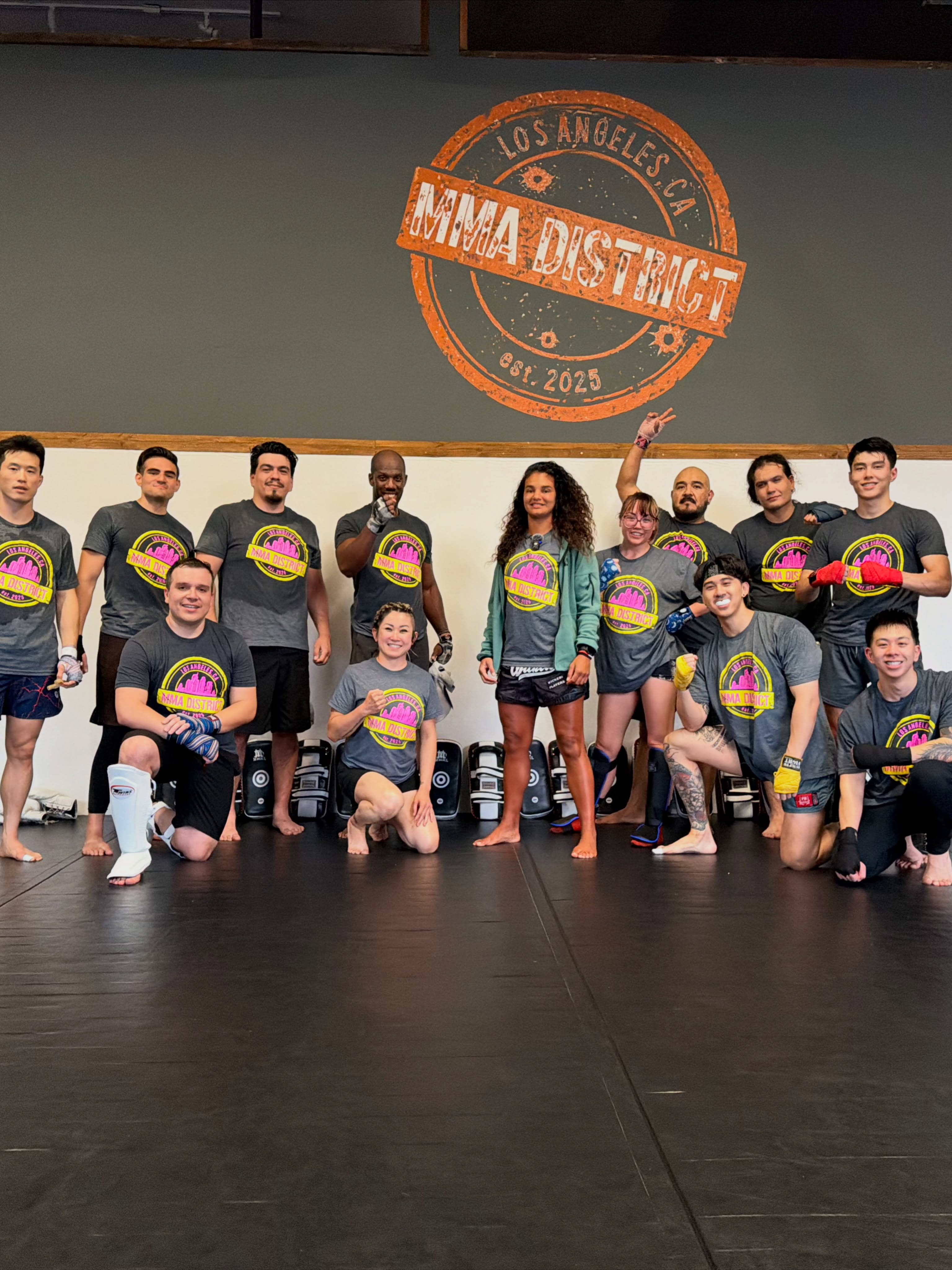 Hanny Tjan with the MMA District team in front of the painted gym logo