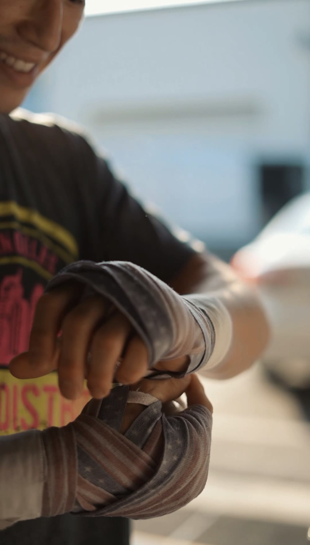 A fighter wrapping their hands before Muay Thai training at MMA District