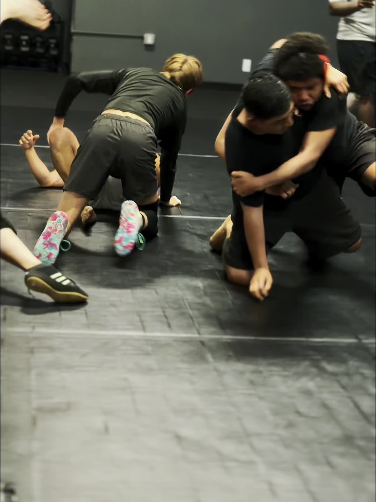 Wrestling at MMA District: a wrestler shooting in on a takedown during live drilling
